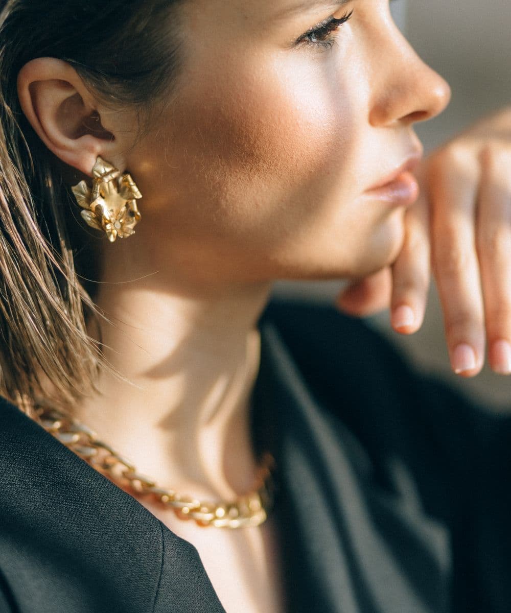 Elegant gold earrings and necklace on woman
